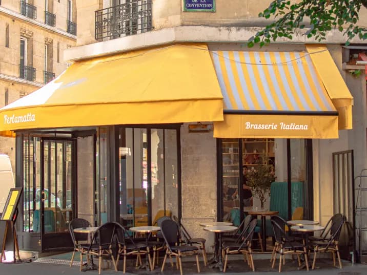La façade de Perlamatta à l’angle de la rue de la Convention : stores jaunes « Brasserie Italiana » et terrasse